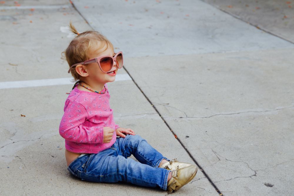 baby wearing sunglasses and gold freshly picked shoes