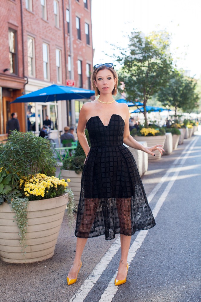 Jordan Reid wearing a little black dress from Saks Fifth Avenue and yellow Christian Louboutin heels