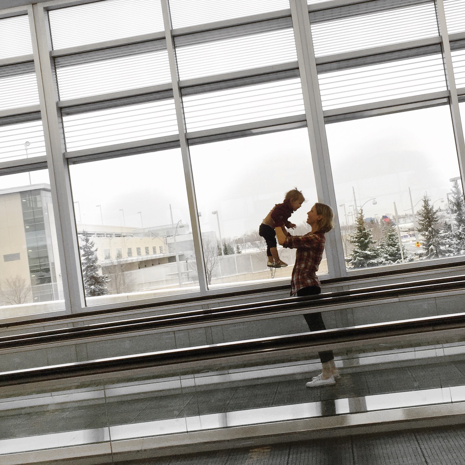 Playing with baby on an airport moving sidewalk