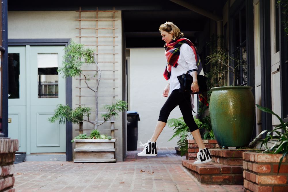 Black and white DKNY high-top sneakers and black leggings