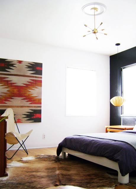 Midcentury rustic room with wall hanging and cow print chair
