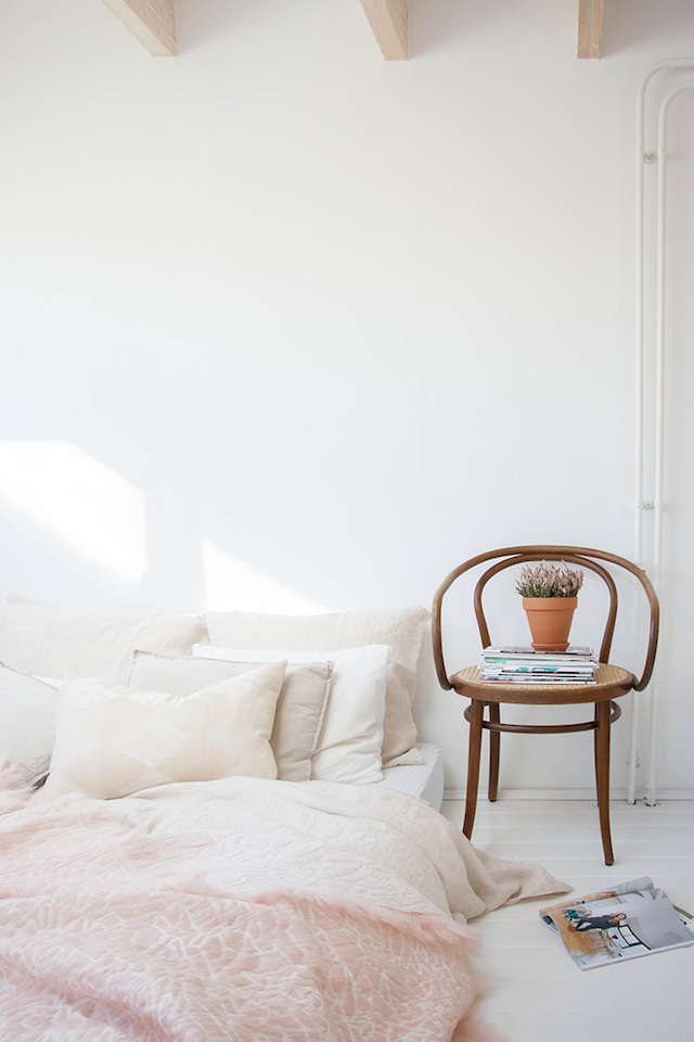 white bedroom with white walls and a low bed