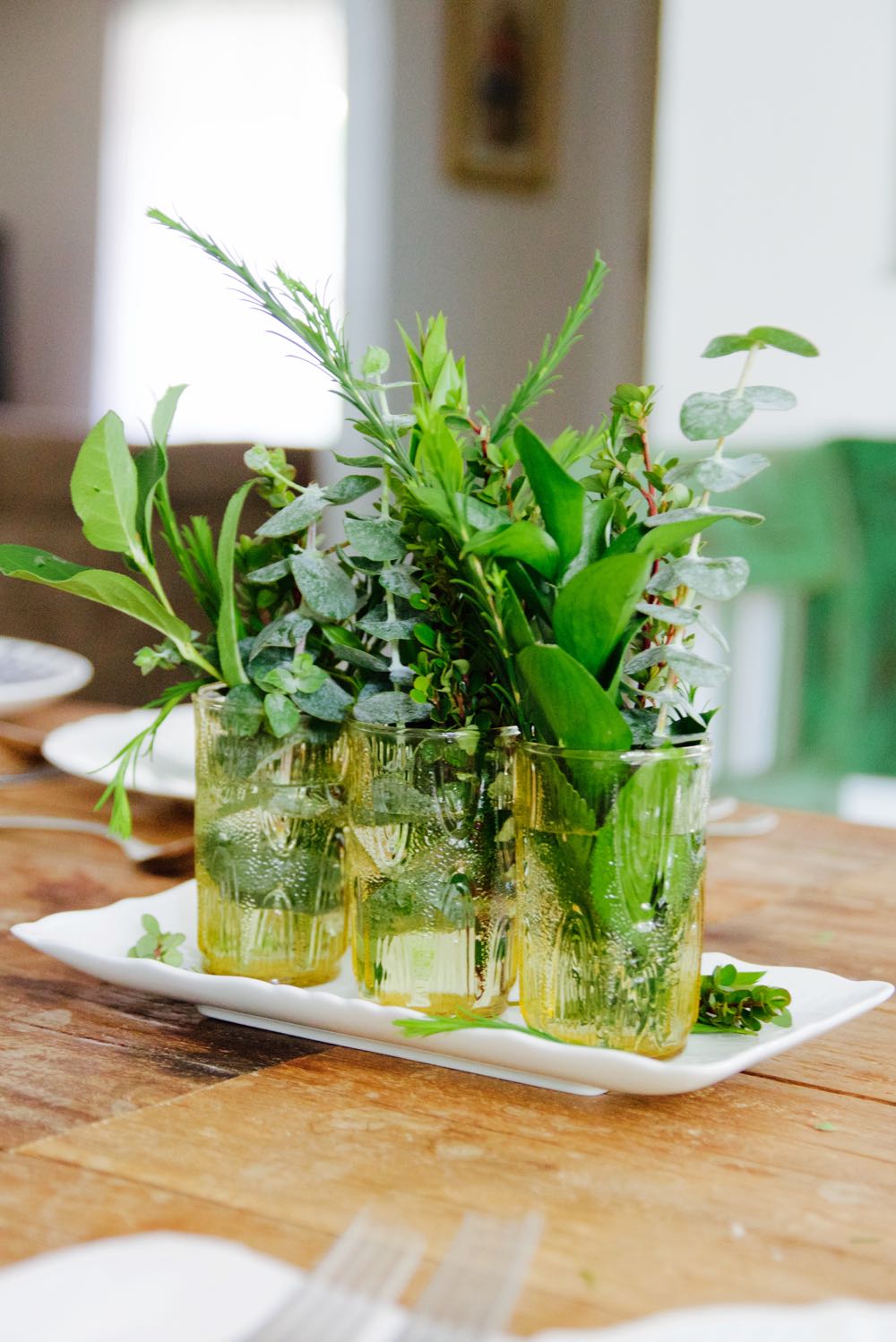 Simple centerpiece of greenery in vintage glasses