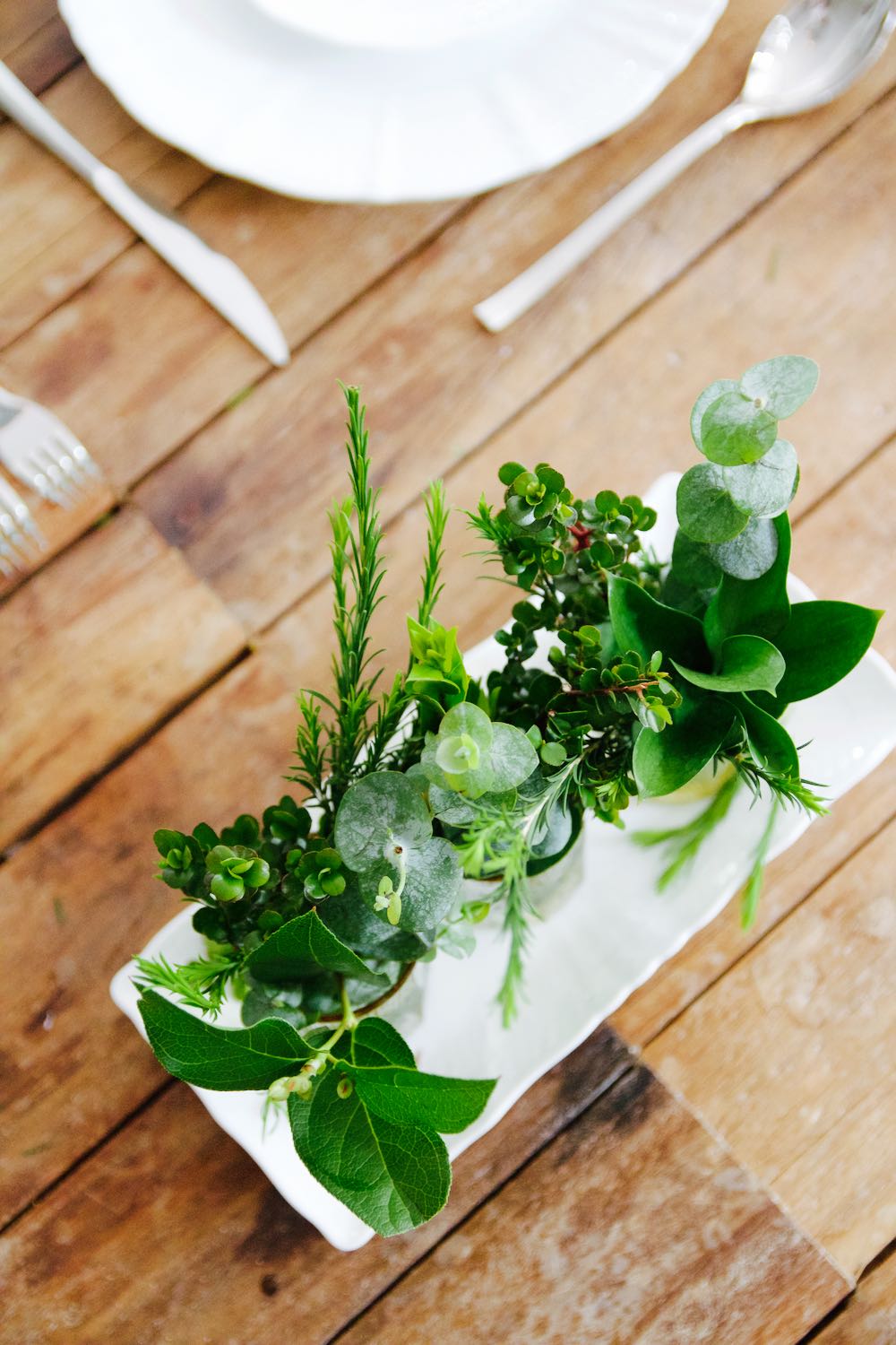 Simple centerpiece of grocery store greens in vintage glasses