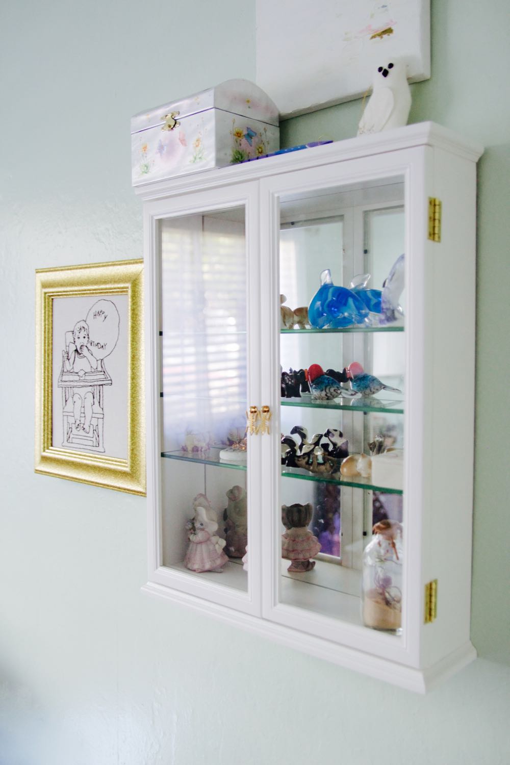 China cabinet with miniature crystal figurines