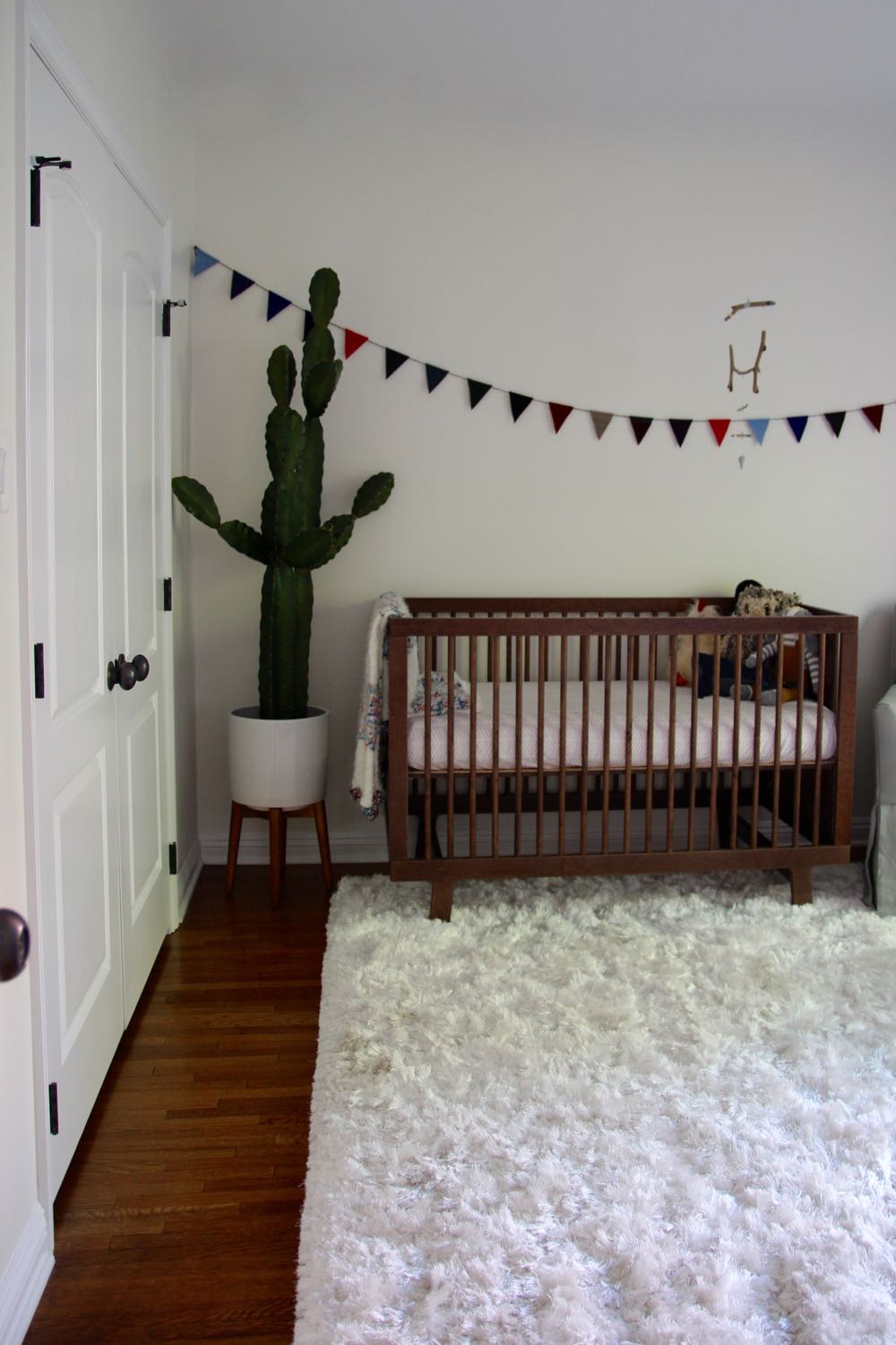 Clean and modern baby nursery with cactus and flags